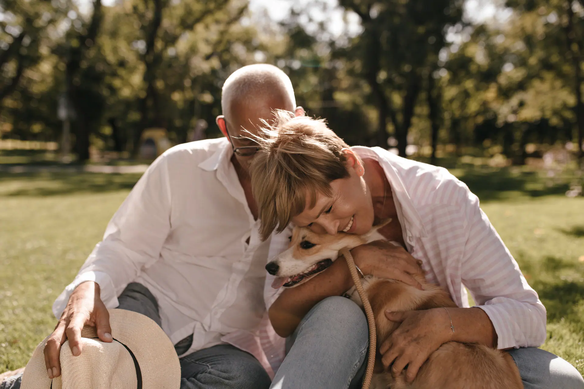 Two people outdoors with a corgi